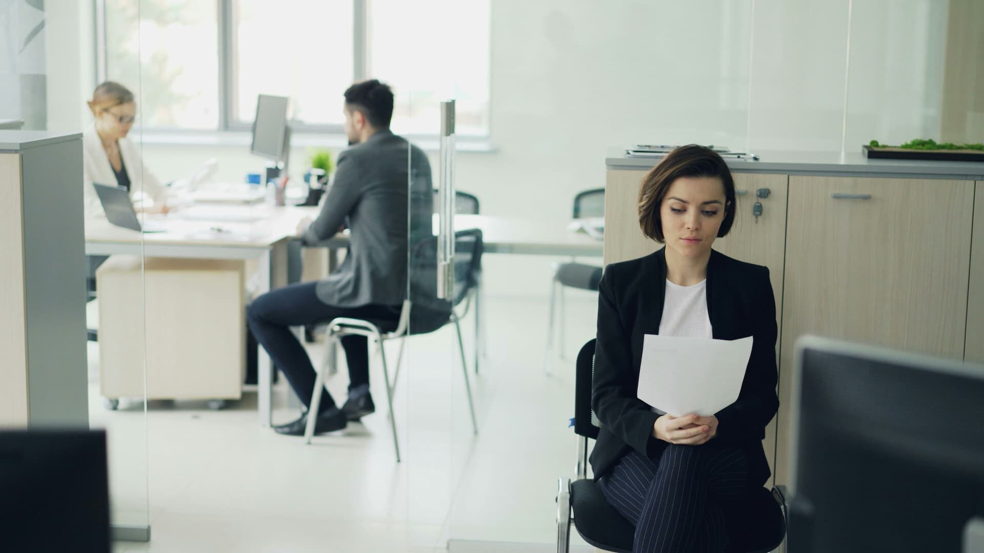 Person reading documents while waiting in an office
