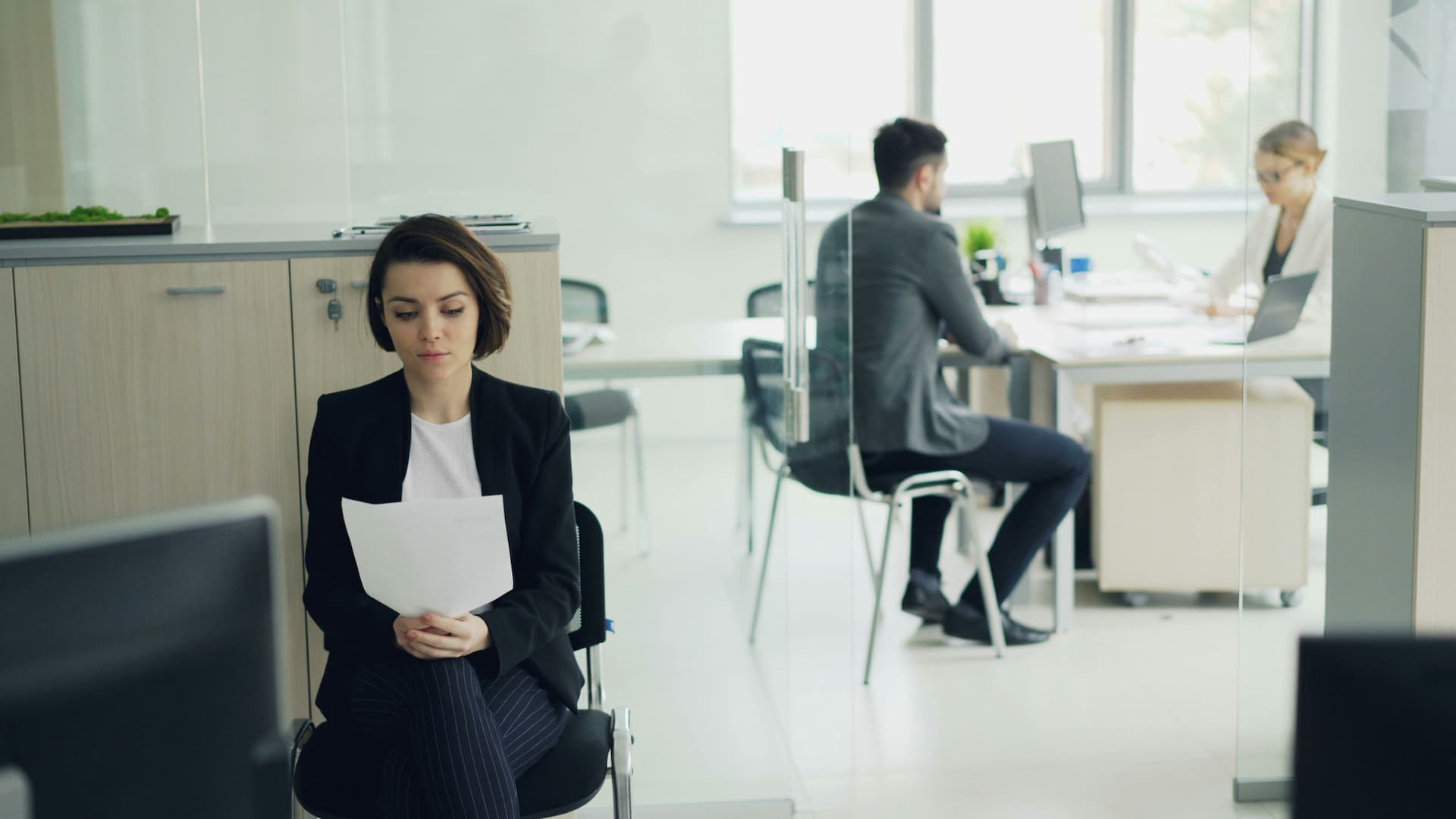 Une personne lisant des documents pendant qu'elle attend dans un bureau